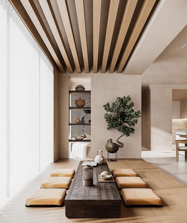Intérieur épuré et chaleureux pour une expertise Feng Shui de l'habitat, avec table basse en bois brut, coussins d'assise et bonsaï.